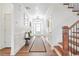 Bright foyer with hardwood floors, white wainscoting, and an elegant staircase at 5310 Chestnut Dr, Cumming, GA 30040