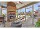 Relaxing sunroom with a brick fireplace, stone floors, and a view of the backyard at 5310 Chestnut Dr, Cumming, GA 30040