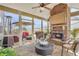 Cozy sunroom featuring a brick fireplace, stone floors, and access to outdoor space at 5310 Chestnut Dr, Cumming, GA 30040