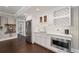 Basement bar area with stainless fridge, white cabinets, wine rack and view to billiards area at 103 Brightmoor Ct, Canton, GA 30115