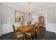Formal dining room with dark wood floors, chandelier, and wainscoting at 103 Brightmoor Ct, Canton, GA 30115
