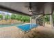 Outdoor patio with a ping pong table overlooking a pristine pool and waterfall feature at 103 Brightmoor Ct, Canton, GA 30115