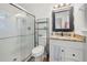 Bright bathroom with a glass shower, granite countertop, modern hardware and plank flooring at 245 Amanda Ct, Stockbridge, GA 30281
