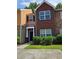 Charming multi-level townhome featuring a brick facade and manicured landscaping at 2612 Haligan Pt, Riverdale, GA 30296