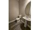 This powder room features a pedestal sink, an oval mirror, and a modern toilet at 2612 Haligan Pt, Riverdale, GA 30296