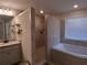 Luxurious bathroom features a tiled shower, soaking tub, double vanity, and linen storage at 2647 Old Snapping Shoals Rd, Mcdonough, GA 30252