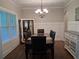 Elegant dining room with a dark wood table, decorative lighting, and paneled walls at 2647 Old Snapping Shoals Rd, Mcdonough, GA 30252