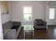 Inviting living room featuring a gray sofa and chair, wood floors, and natural light at 2647 Old Snapping Shoals Rd, Mcdonough, GA 30252