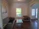 Inviting living room with a gray sofa and chair, wood floors, and natural light at 2647 Old Snapping Shoals Rd, Mcdonough, GA 30252