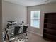 Well-lit office features a glass desk, rolling chairs, and a built-in bookshelf at 2647 Old Snapping Shoals Rd, Mcdonough, GA 30252