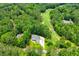 Aerial view of home next to a golf course surrounded by lush trees at 7037 Tara Dr, Villa Rica, GA 30180