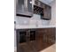 Wet bar area featuring dark cabinets with glass doors, wine rack, stone countertop, and stainless sink at 7037 Tara Dr, Villa Rica, GA 30180