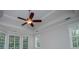 Bright bedroom featuring tray ceilings, ceiling fan, and large windows at 7037 Tara Dr, Villa Rica, GA 30180