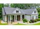 Charming home featuring stone accents, a covered porch with stately columns, and professional landscaping at 7037 Tara Dr, Villa Rica, GA 30180