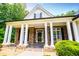 Inviting front porch featuring stately columns, stone accents, and a well-manicured garden at 7037 Tara Dr, Villa Rica, GA 30180