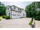 Three car garage with black shutters and surrounded by luscious green trees at 7037 Tara Dr, Villa Rica, GA 30180