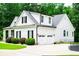 Three car garage featuring black shutters, green landscaping and well manicured lawn at 7037 Tara Dr, Villa Rica, GA 30180