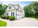 View of the three car garage, black shutters, and well maintained landscaping of the home at 7037 Tara Dr, Villa Rica, GA 30180