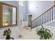 Bright foyer with tile flooring, leading to a staircase with wooden handrails, and view of the living room at 226 Creek View Ln, Acworth, GA 30102