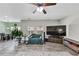 Cozy living room featuring wood laminate floors, ceiling fan and television at 226 Creek View Ln, Acworth, GA 30102