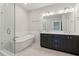 Modern bathroom featuring a glass-enclosed shower, soaking tub, and double sink vanity at 2734 Bell Se Dr, Smyrna, GA 30080