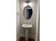 Half bathroom featuring a pedestal sink, oval mirror, and modern lighting at 2734 Bell Se Dr, Smyrna, GA 30080