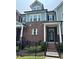 Charming three-story townhome with brick facade and black metal fencing, creating a welcoming curb appeal at 2734 Bell Se Dr, Smyrna, GA 30080