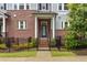 Close up of a brick townhome featuring a black wrought iron fence and covered entryway with white columns at 2734 Bell Se Dr, Smyrna, GA 30080
