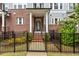 Close up of a brick townhome featuring a black wrought iron fence and covered entryway with white columns at 2734 Bell Se Dr, Smyrna, GA 30080