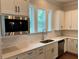 Close-up of kitchen with stainless steel sink, quartz countertops, white subway tile backsplash, and cabinetry at 2734 Bell Se Dr, Smyrna, GA 30080