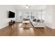 Light-filled living room boasts hardwood floors, gray sofas, a ceiling fan, and large windows at 2734 Bell Se Dr, Smyrna, GA 30080