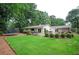 Expansive backyard featuring a lush lawn, patio seating, and mature trees, creating an outdoor oasis at 3850 Beya Way, Atlanta, GA 30340