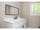 Bathroom vanity with a white cabinet, quartz countertop, a modern faucet, and a framed mirror at 3850 Beya Way, Atlanta, GA 30340