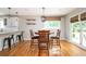 Open dining area with hardwood floors and a modern light fixture, next to the breakfast bar and overlooking the yard at 3850 Beya Way, Atlanta, GA 30340
