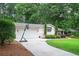 View of home with a two-car garage and basketball hoop in the driveway, surrounded by lush greenery at 3850 Beya Way, Atlanta, GA 30340