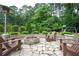 Beautiful backyard area with stone fire pit, Adirondack chairs, and professionally landscaped greenery at 3850 Beya Way, Atlanta, GA 30340