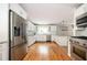 Bright kitchen featuring white cabinets, stainless steel appliances, hardwood floors and a large sink by the window at 3850 Beya Way, Atlanta, GA 30340
