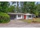 Exterior view showcasing the house with a carport and a well-manicured lawn at 4922 Glenside Ct, Stone Mountain, GA 30088