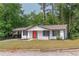 Charming ranch-style home featuring a well-manicured lawn, red front door, white siding, and a cozy, inviting curb appeal at 4922 Glenside Ct, Stone Mountain, GA 30088