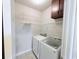 Efficient laundry room with washer, dryer, shelving, and cabinetry for storage needs at 210 Morning Dove Ln, Suwanee, GA 30024