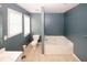 Bathroom with tile floors featuring a toilet and a large bathtub at 940 Sandy Ford Rd, Social Circle, GA 30025