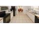 Open kitchen with tile flooring, white cabinets and modern appliances, including a black refrigerator and range at 940 Sandy Ford Rd, Social Circle, GA 30025