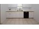 Bright kitchen features white cabinetry, tile flooring, and a stainless steel sink with updated fixtures at 940 Sandy Ford Rd, Social Circle, GA 30025