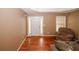 Welcoming living room with hardwood floors, chair and bright white door at 940 Sandy Ford Rd, Social Circle, GA 30025