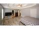 Spacious main bedroom with tray ceilings, ceiling fan, and light wood-look flooring at 940 Sandy Ford Rd, Social Circle, GA 30025