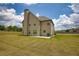 Expansive backyard showcases a two-story home with a chimney, patio, and well-maintained lawn at 200 Baumgard Way, Locust Grove, GA 30248