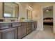 Bathroom vanity with double sinks, granite counters, and tile flooring leads into bedroom at 200 Baumgard Way, Locust Grove, GA 30248