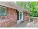 Brick home with a wood porch, accessed by glass double doors, featuring the word 'hello' on the doormat at 4266 Roswell Ne Rd # L3, Atlanta, GA 30342