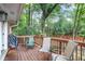 Outdoor wooden deck featuring chairs and a grill, backing up to a lush green wooded area at 4266 Roswell Ne Rd # L3, Atlanta, GA 30342