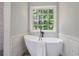 Bright bathroom showcasing a freestanding tub beneath a window offering a lush outdoor view at 232 Barrett Springs Way, Canton, GA 30115